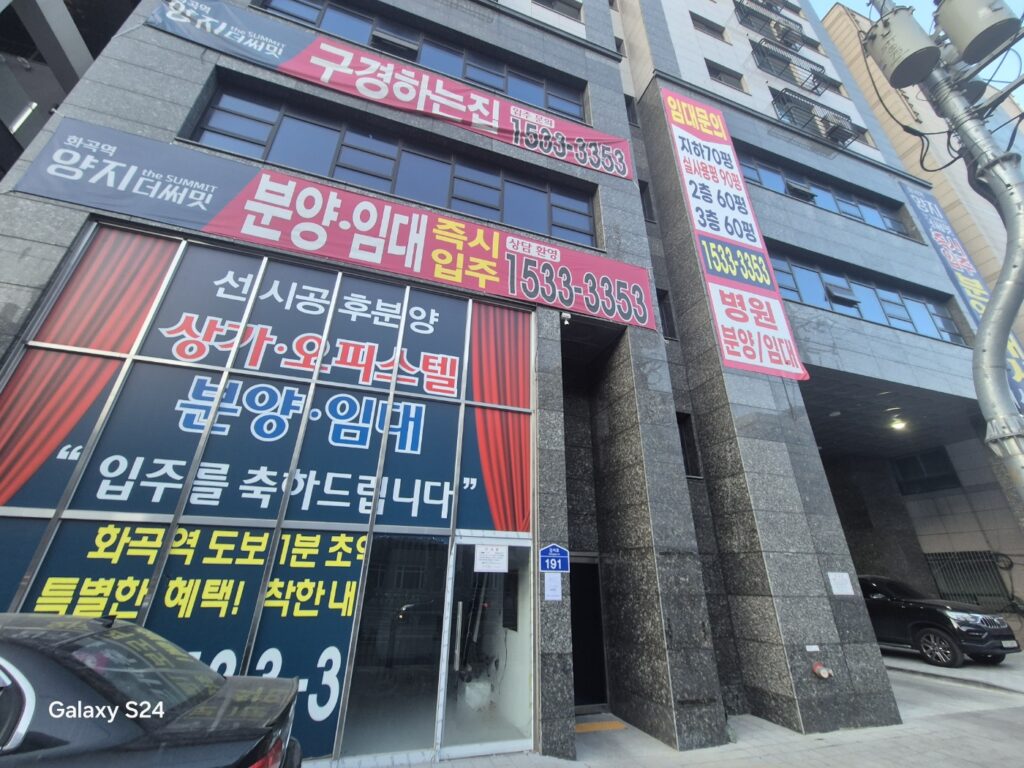 분양 현수막과 시트지가 붙어 있는 상가 건물 전면