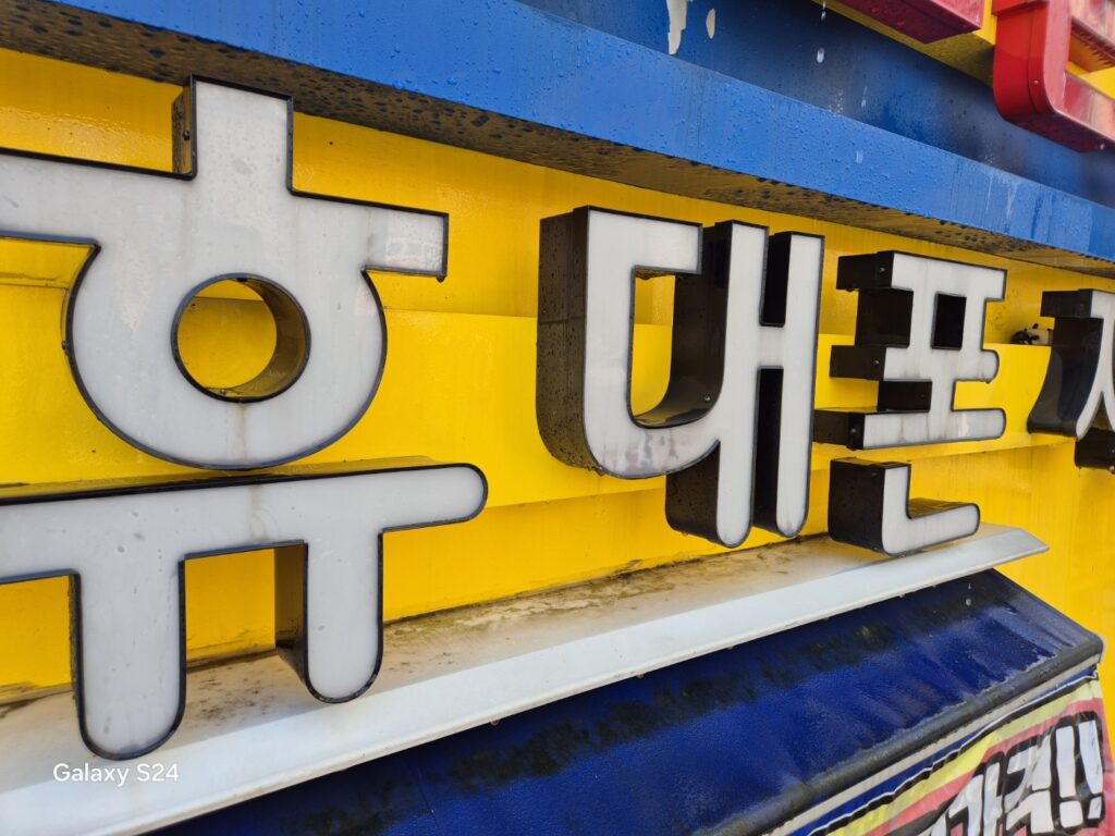 먼지와 때가 낀 상가 채널 간판 글자 근접 사진
