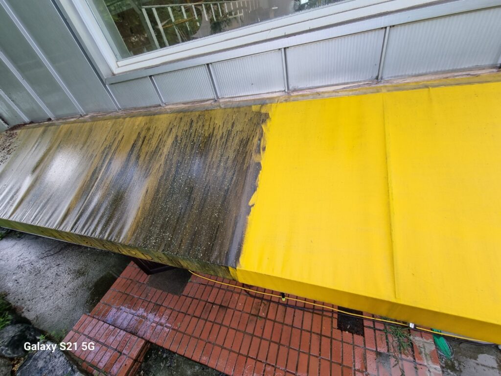 절반만 세척되어 원래 노란색이 드러난 어닝 천막